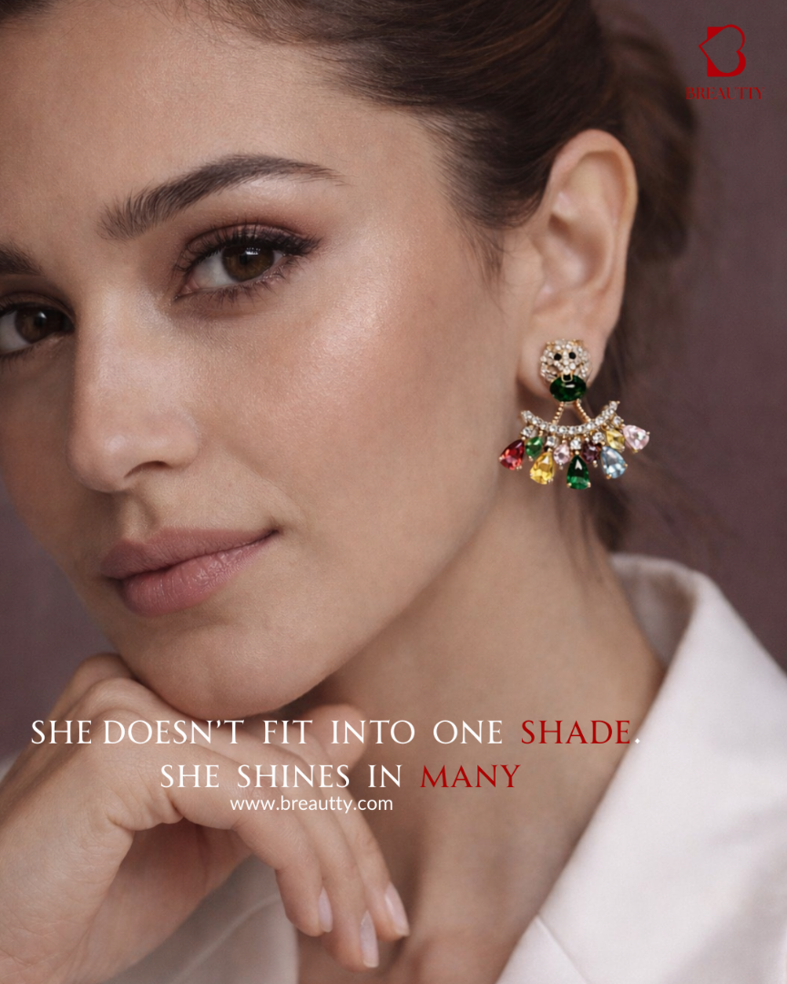 Woman wearing colorful earrings with a quote about skin tones on a brown background